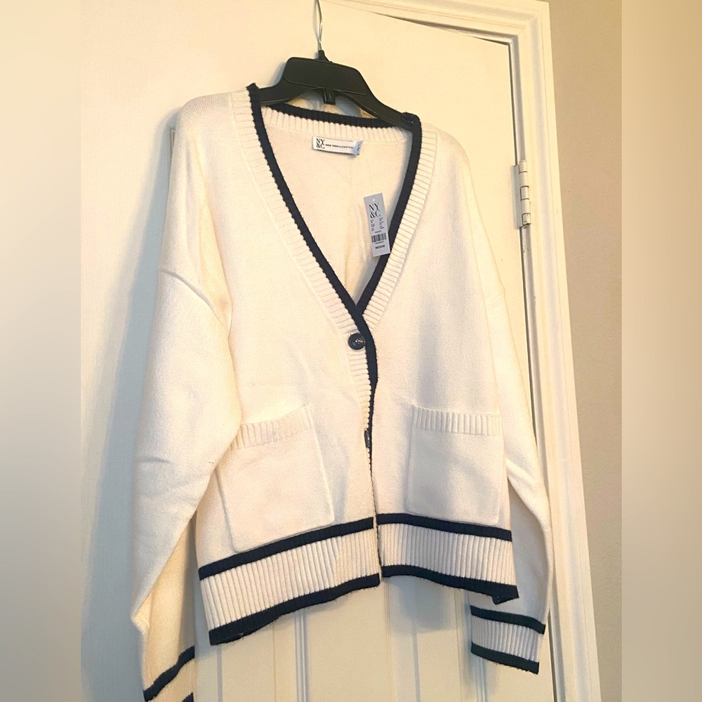 White button up cardigan with black trim.